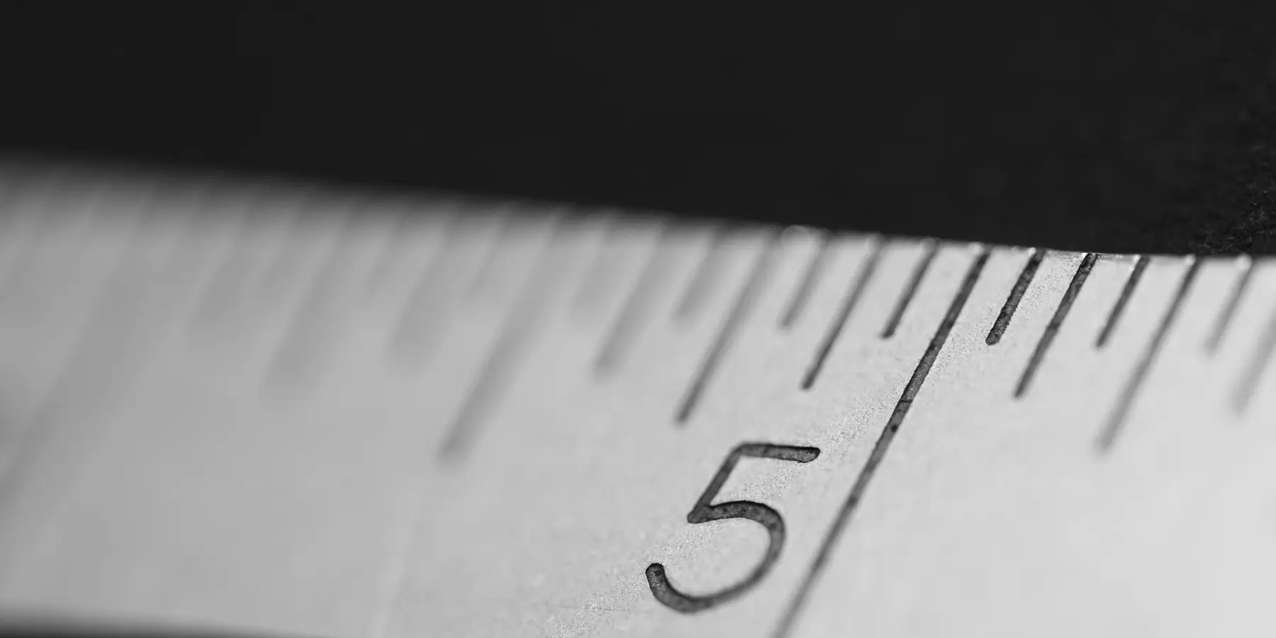Macro of a steel ruler's graduation marks on a dark background