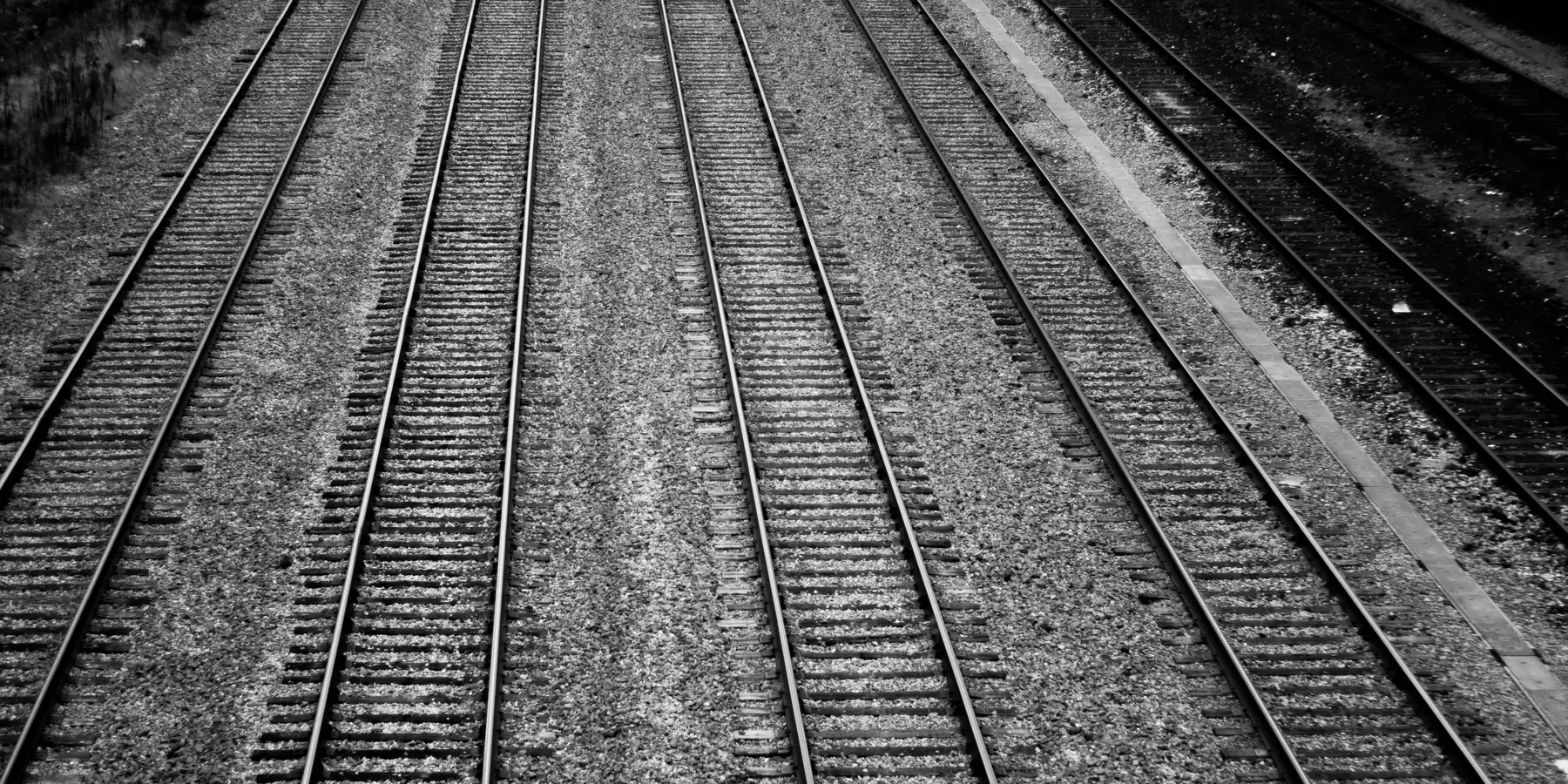 Parallel railway tracks running through gravel, seen from above