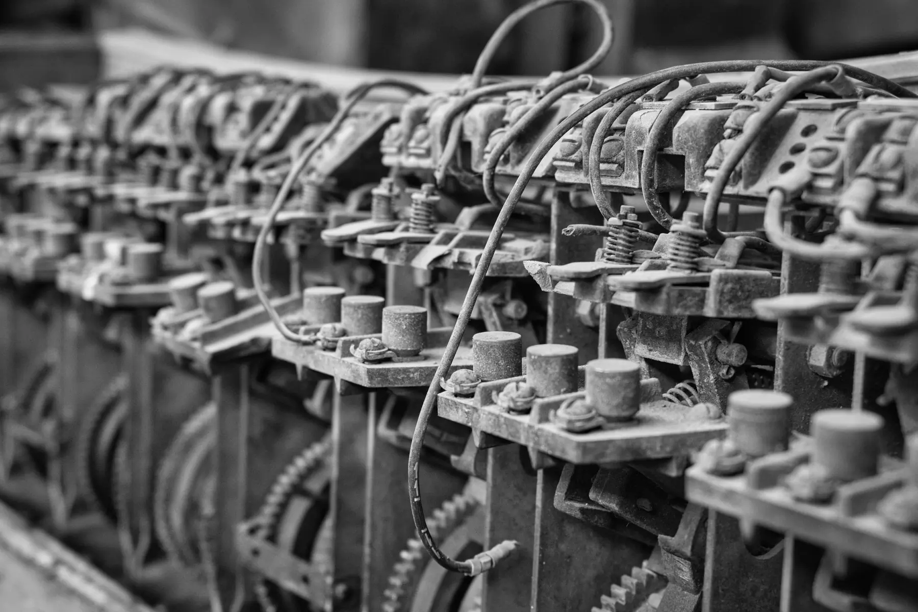 Rows of identical bolts, springs and wires on an old machine