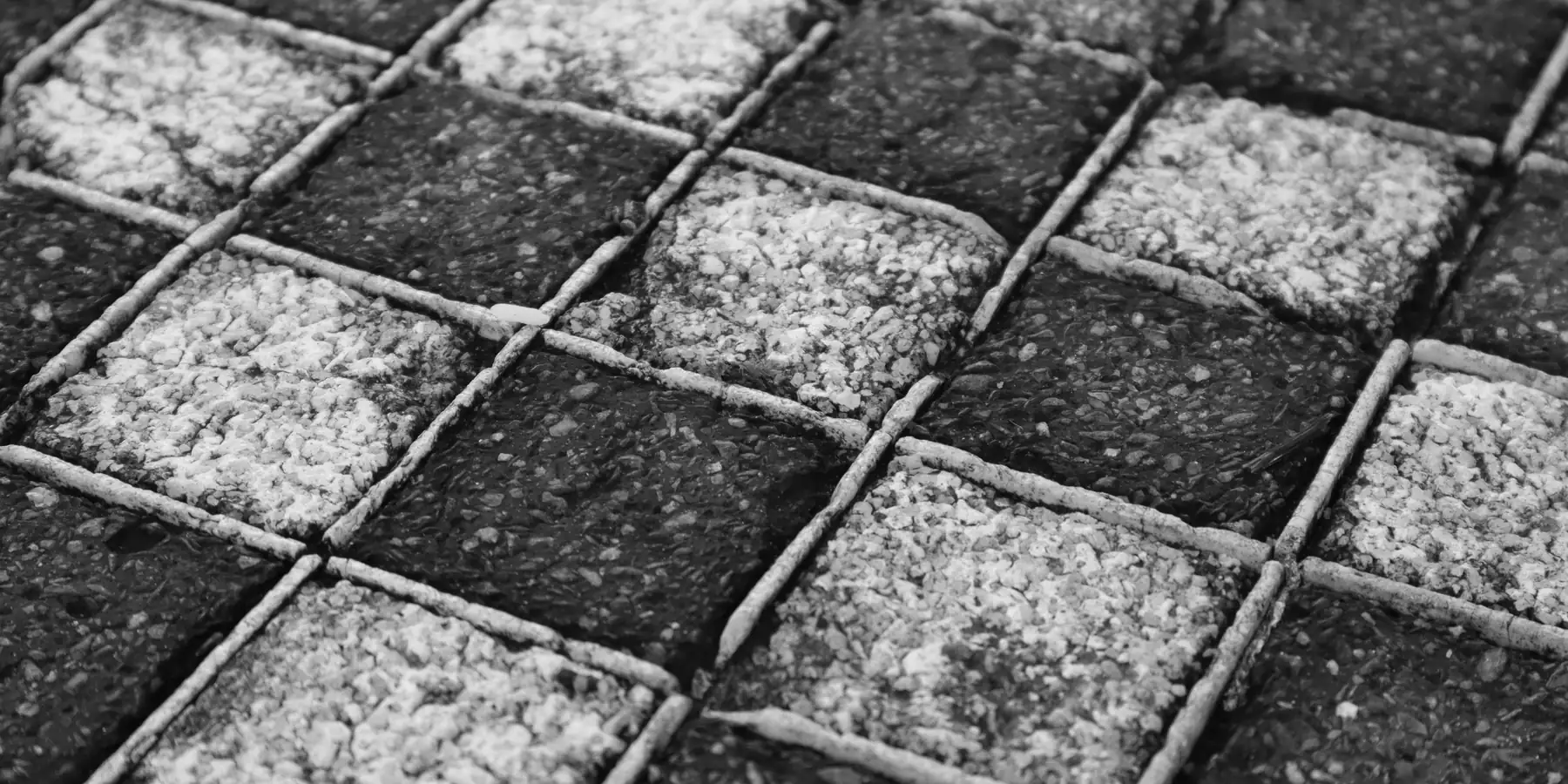 Grid of dark and pale gravel paving squares divided by thin joints