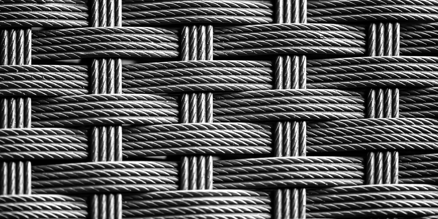 Close-up of thick twisted dark strands woven in an over-under basket pattern